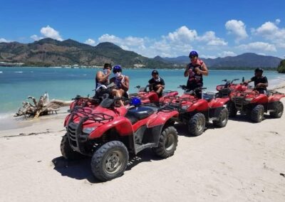 Grupo con cuatrimotos junto al mar y las montañas