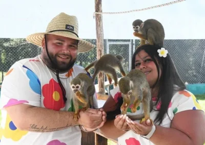 Dos visitantes con monos ardilla durante la excursión